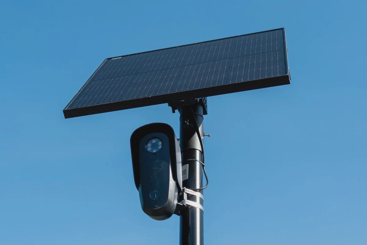 Camera đọc biển số Flock gắn trên cột cùng tấm pin mặt trời dưới trời xanh