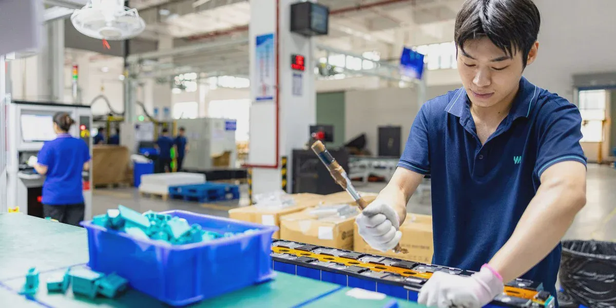Công nhân thao tác tại bàn lắp ráp trong nhà máy pin