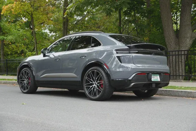 Porsche Macan Turbo điện màu xám đỗ với cánh gió sau mở