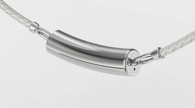 Mặt dây chuyền Nirva đặt cạnh hộp đựng và điện thoại