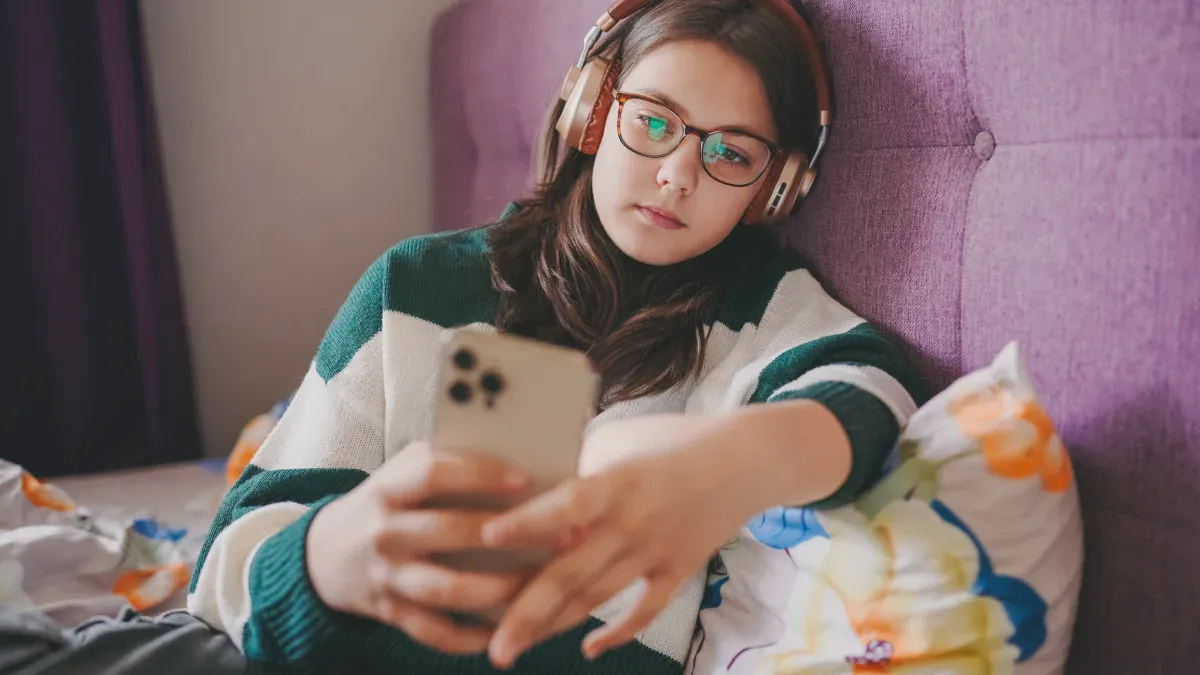 Một người trẻ đeo tai nghe khi sử dụng Spotify